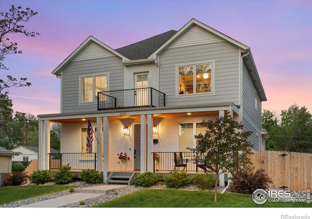 3256 S Corona St, Englewood, CO 80113 - view of front of house with covered porch, a balcony, and brick siding