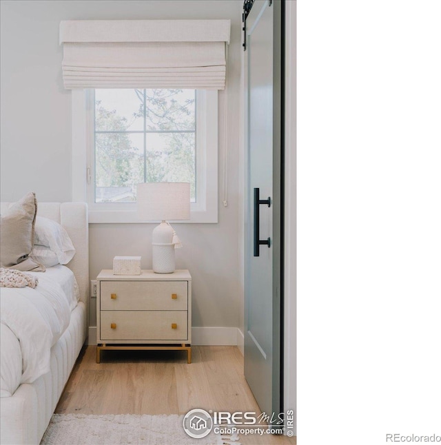 3256 S Corona St, Englewood, CO 80113 - bedroom featuring light wood finished floors and a barn door