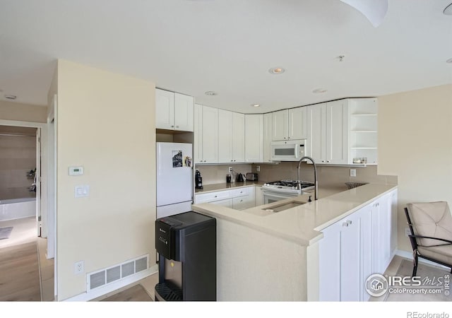 2938 Kalmia Ave Unit 26, Boulder, CO 80301 - kitchen featuring white appliances, open shelves, a peninsula, a sink, and white cabinetry