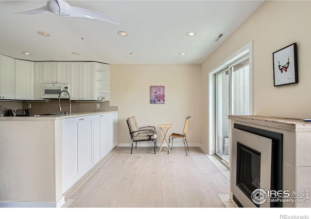 2938 Kalmia Ave Unit 26, Boulder, CO 80301 - kitchen with white microwave, open shelves, white cabinets, light wood-style flooring, and recessed lighting