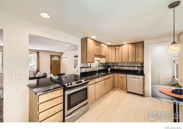630 S 45th St, Boulder, CO 80305 - kitchen featuring stainless steel appliances, dark countertops, light wood finished floors, decorative backsplash, and a sink