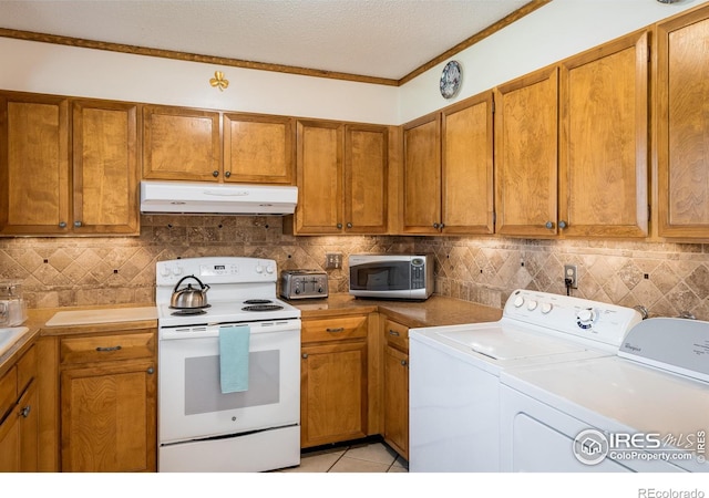 1542 Kilkenny St, Boulder, CO 80303 - kitchen with electric stove, under cabinet range hood, stainless steel microwave, washer and clothes dryer, and brown cabinetry