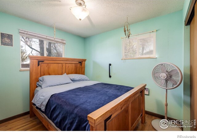 1542 Kilkenny St, Boulder, CO 80303 - bedroom with wood finished floors, a textured ceiling, and baseboards