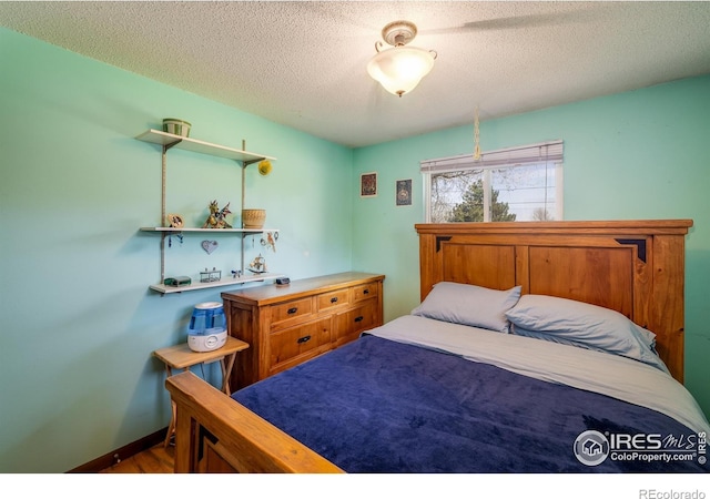 1542 Kilkenny St, Boulder, CO 80303 - bedroom with a textured ceiling, wood finished floors, and baseboards
