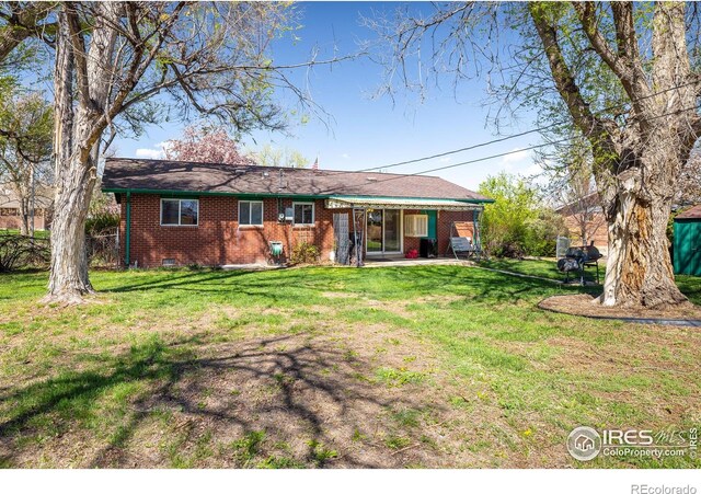 1542 Kilkenny St, Boulder, CO 80303 - rear view of property featuring brick siding, a lawn, and a patio