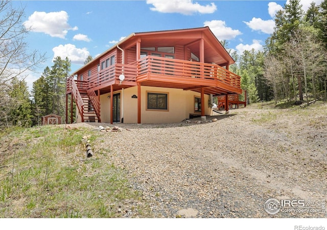 880 Hummer Dr, Nederland, CO 80466 - view of front facade featuring a wooden deck, stucco siding, and stairs