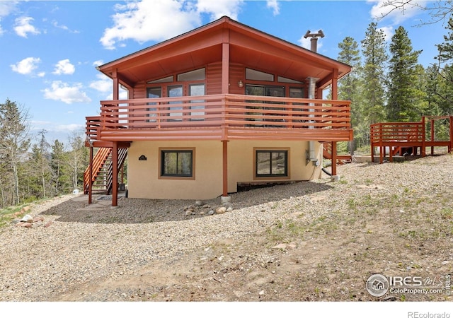 880 Hummer Dr, Nederland, CO 80466 - rear view of property featuring stairway, a deck, and stucco siding