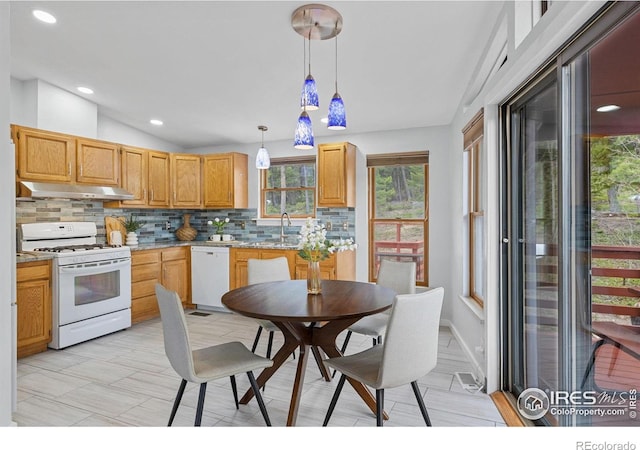 880 Hummer Dr, Nederland, CO 80466 - kitchen with white appliances, under cabinet range hood, backsplash, healthy amount of natural light, and lofted ceiling