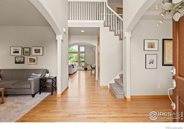 5751 Round Rock Ct, Fort Collins, CO 80528 - entryway featuring arched walkways, light wood-style flooring, stairway, and baseboards