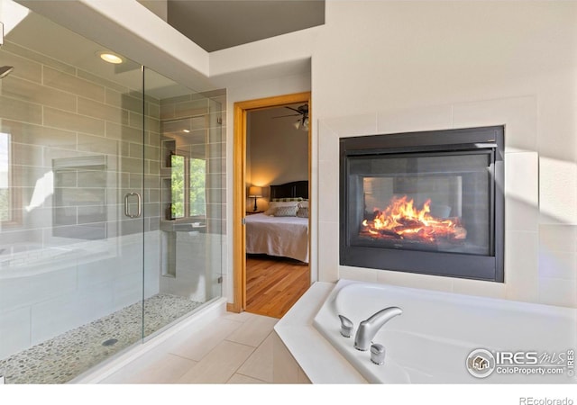 5751 Round Rock Ct, Fort Collins, CO 80528 - bathroom featuring a garden tub, a shower stall, tile patterned flooring, ensuite bath, and a glass covered fireplace