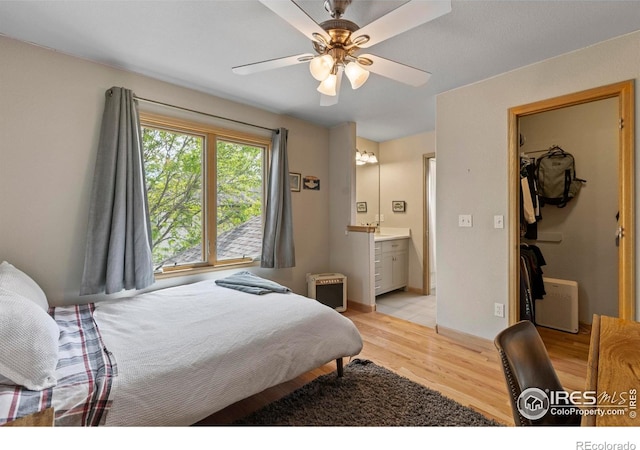 5751 Round Rock Ct, Fort Collins, CO 80528 - bedroom featuring light wood-style floors, a walk in closet, ensuite bath, a sink, and a ceiling fan