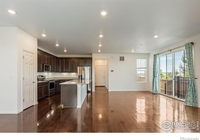 17616 Bluetrail Ave, Parker, CO 80134 - kitchen featuring stainless steel appliances, dark brown cabinetry, dark wood-type flooring, a kitchen island with sink, and recessed lighting