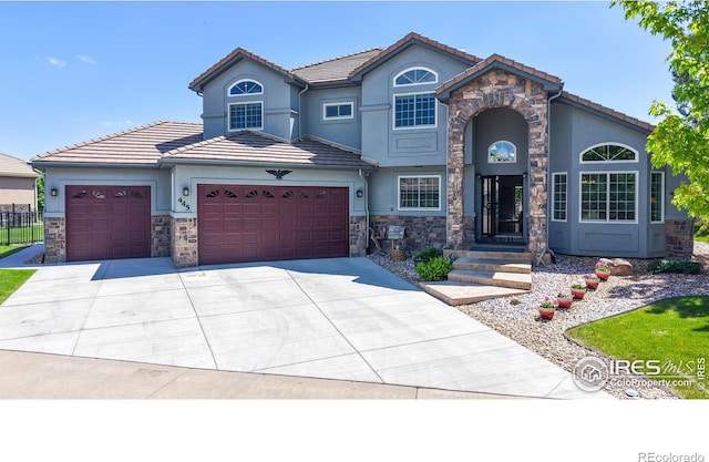 445 Whitney Hbr, Windsor, CO 80550 - view of front of property featuring stucco siding, an attached garage, stone siding, and driveway