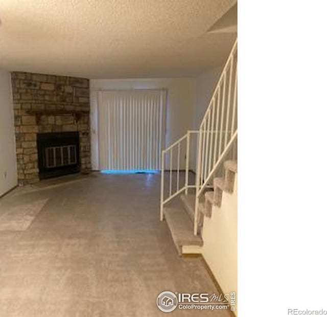 2929 W 81st Ave Unit H, Westminster, CO 80031 - unfurnished living room featuring stairs, a textured ceiling, a fireplace, and carpet