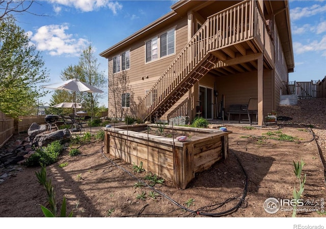 4000 Donnington Cir, Castle Rock, CO 80104 - rear view of house featuring stairway, a wooden deck, a vegetable garden, and a patio area