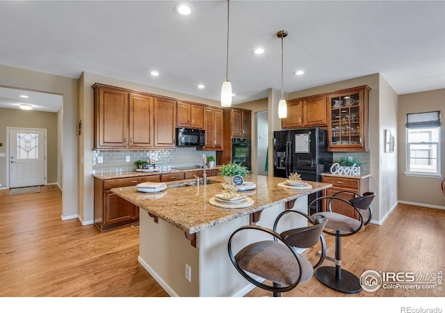 4000 Donnington Cir, Castle Rock, CO 80104 - kitchen featuring black appliances, brown cabinetry, light wood-style flooring, and recessed lighting