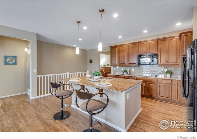 4000 Donnington Cir, Castle Rock, CO 80104 - kitchen with black appliances, light wood-style flooring, brown cabinets, and recessed lighting