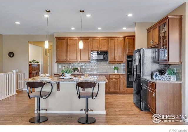 4000 Donnington Cir, Castle Rock, CO 80104 - kitchen featuring black appliances, light wood-style floors, brown cabinetry, and recessed lighting