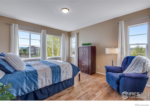 4000 Donnington Cir, Castle Rock, CO 80104 - bedroom featuring multiple windows, light wood finished floors, and baseboards