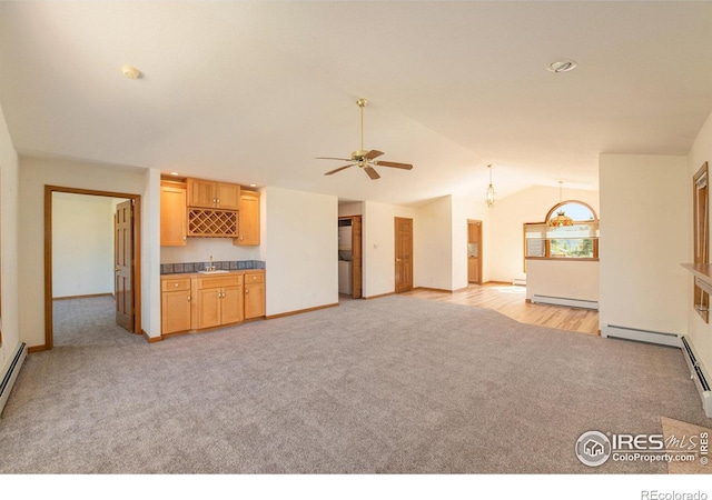 683 Cedar Ridge Cir, Estes Park, CO 80517 - unfurnished living room with light carpet, a baseboard heating unit, vaulted ceiling, baseboards, and a ceiling fan
