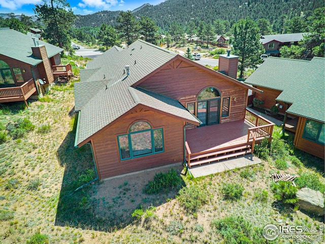 683 Cedar Ridge Cir, Estes Park, CO 80517 - back of property with a chimney, a deck with mountain view, and a shingled roof