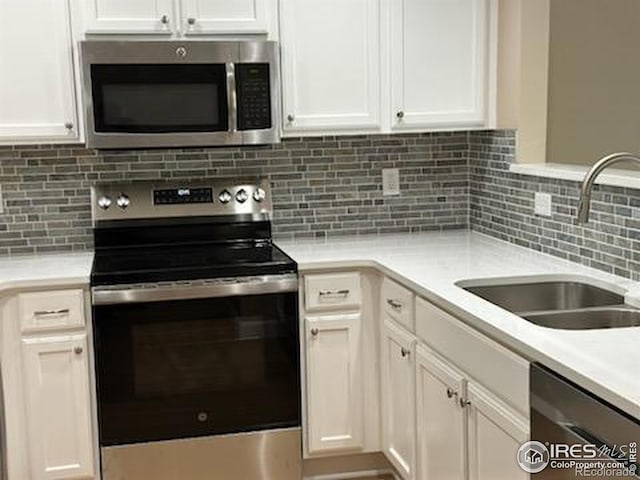 2218 Stetson Creek Dr Unit C, Fort Collins, CO 80528 - kitchen featuring stainless steel appliances, a sink, white cabinets, light countertops, and tasteful backsplash
