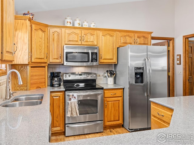 3807 Dollar Lake Dr, Estes Park, CO 80517 - kitchen featuring appliances with stainless steel finishes, a sink, tasteful backsplash, light wood-type flooring, and light stone countertops