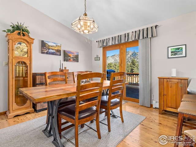 3807 Dollar Lake Dr, Estes Park, CO 80517 - dining area featuring light wood finished floors, vaulted ceiling, a baseboard heating unit, and a chandelier