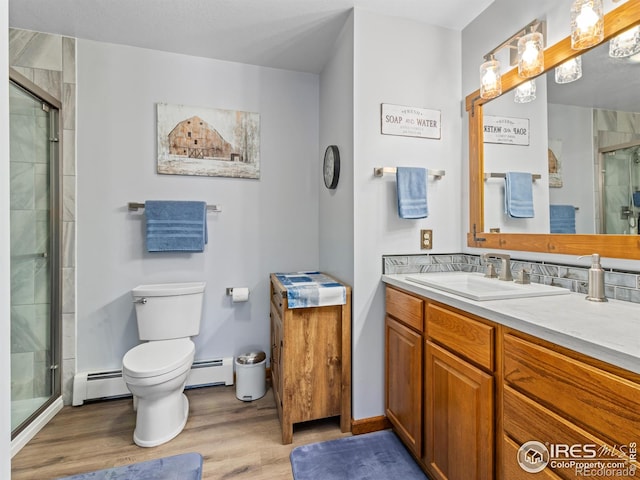 3807 Dollar Lake Dr, Estes Park, CO 80517 - full bathroom featuring a baseboard heating unit, wood finished floors, vanity, and toilet