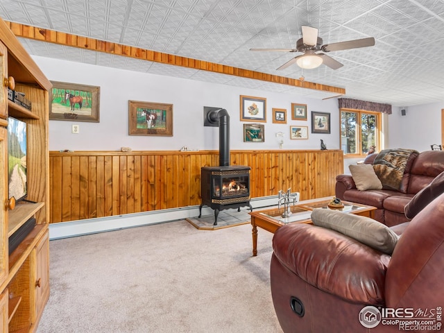 3807 Dollar Lake Dr, Estes Park, CO 80517 - living area with a wood stove, wainscoting, wood walls, carpet, and ceiling fan