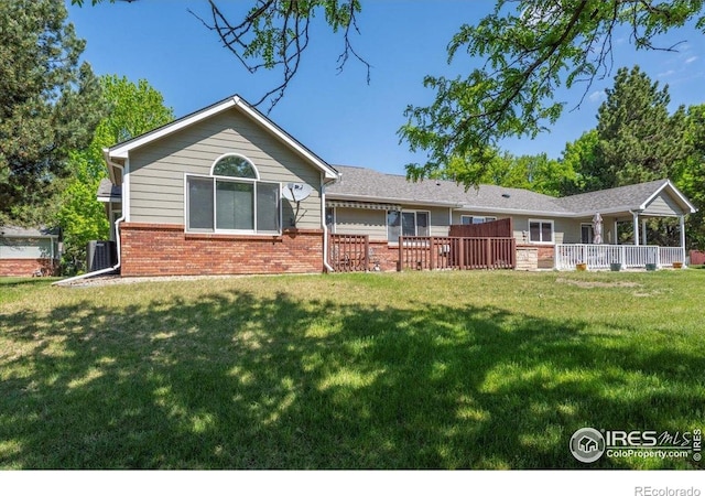 1528 16th Pl, Longmont, CO 80501 - back of house with brick siding, a yard, and central air condition unit