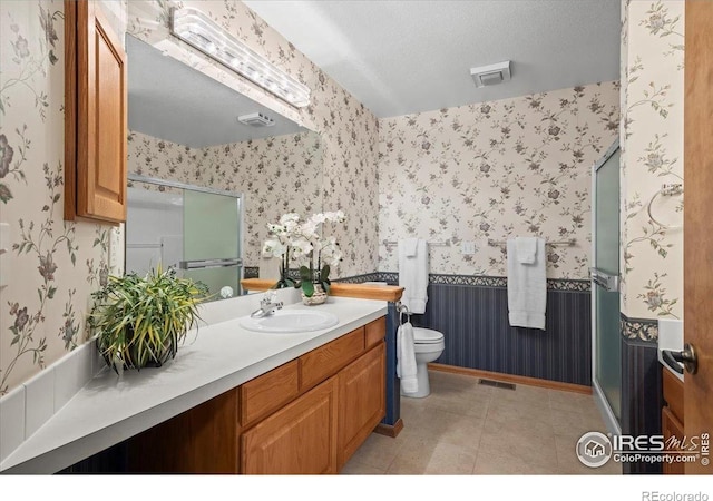 1528 16th Pl, Longmont, CO 80501 - full bath featuring wallpapered walls, toilet, vanity, tile patterned flooring, and baseboards