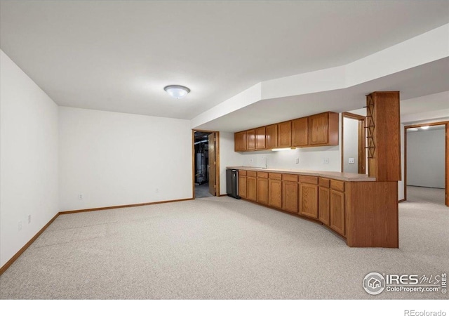 1528 16th Pl, Longmont, CO 80501 - kitchen with light colored carpet, light countertops, baseboards, and brown cabinets
