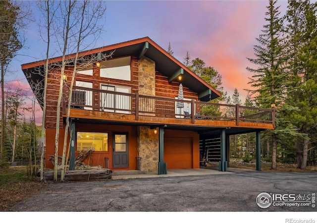 216 N Gold Flake, Breckenridge, CO 80424 - view of front of property featuring a garage, driveway, stone siding, a wooden deck, and stairway