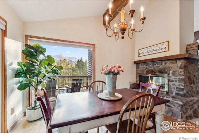216 N Gold Flake, Breckenridge, CO 80424 - dining room with wood finished floors, vaulted ceiling, a fireplace, a chandelier, and a mountain view