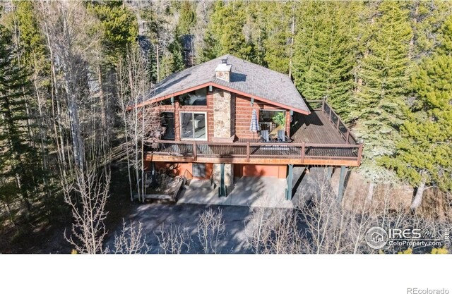 216 N Gold Flake, Breckenridge, CO 80424 - view of front facade featuring a view of trees, a carport, driveway, a deck, and a patio area