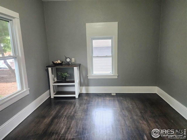 936 E 4th St, Loveland, CO 80537 - empty room featuring plenty of natural light, dark wood finished floors, and baseboards