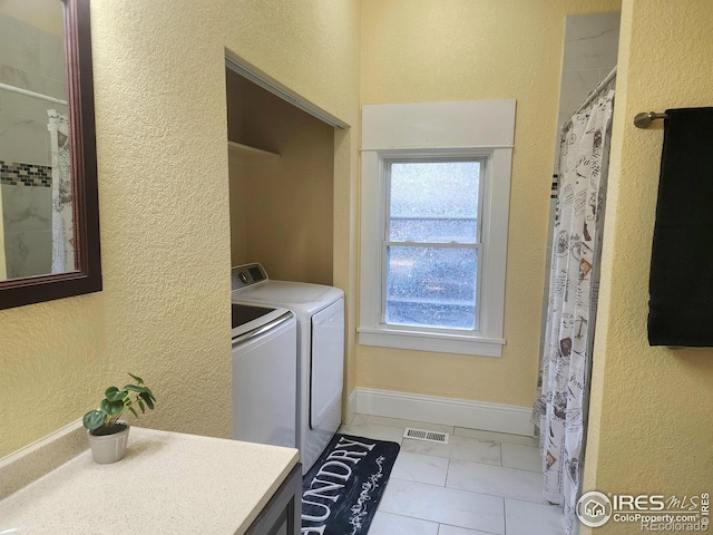 936 E 4th St, Loveland, CO 80537 - laundry area featuring separate washer and dryer, a textured wall, marble look tile flooring, and baseboards