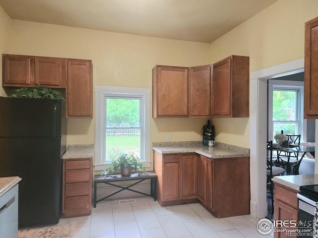 936 E 4th St, Loveland, CO 80537 - kitchen featuring freestanding refrigerator, light countertops, and brown cabinets