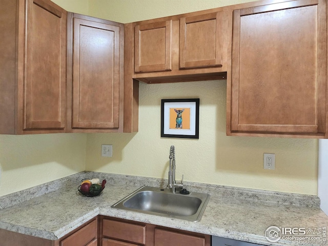 936 E 4th St, Loveland, CO 80537 - kitchen featuring a sink, light countertops, brown cabinetry, and a textured wall