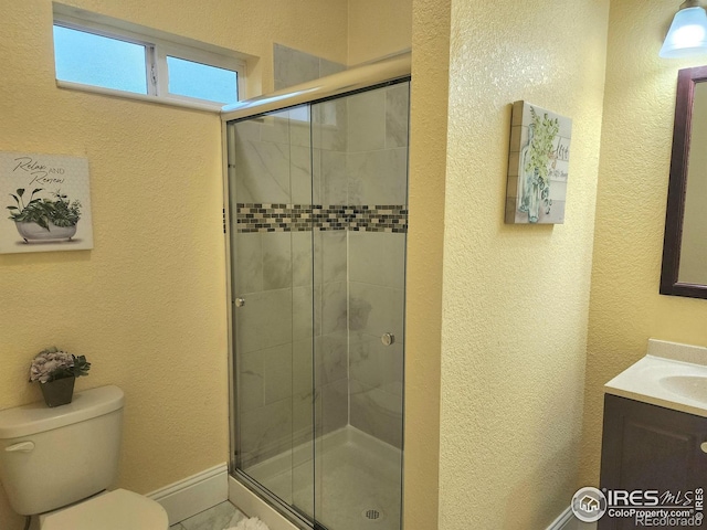 936 E 4th St, Loveland, CO 80537 - full bath featuring toilet, vanity, a stall shower, a textured wall, and baseboards
