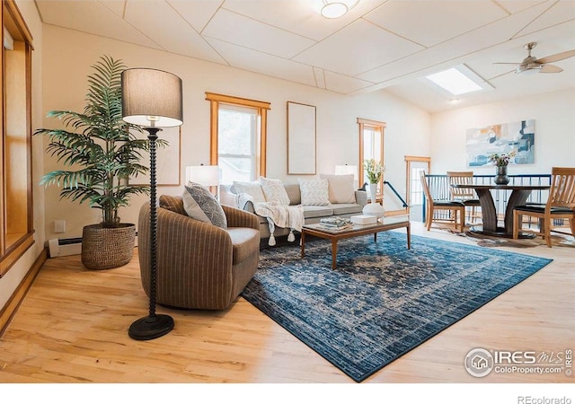 1155 Monroe Ave, Loveland, CO 80537 - living area with a baseboard heating unit, wood finished floors, vaulted ceiling, and ceiling fan