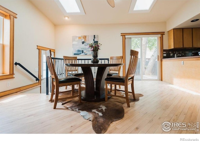 1155 Monroe Ave, Loveland, CO 80537 - dining room featuring a skylight, light wood-style flooring, and vaulted ceiling