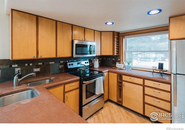 1155 Monroe Ave, Loveland, CO 80537 - kitchen with appliances with stainless steel finishes, light wood finished floors, backsplash, a sink, and recessed lighting