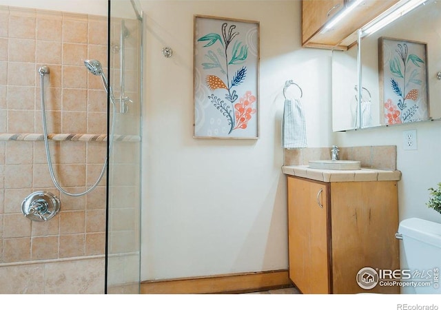 1155 Monroe Ave, Loveland, CO 80537 - bathroom featuring toilet, vanity, and tiled shower
