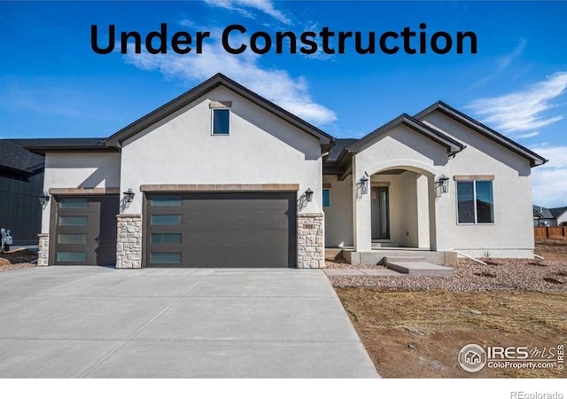 31 Snowcap Dr, Windsor, CO 80550 - view of front of house featuring stucco siding, a garage, driveway, and stone siding
