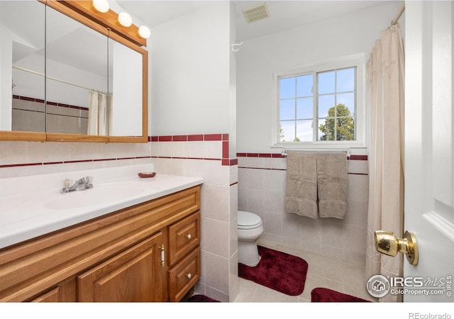 266 Gap Rd, Black Hawk, CO 80422 - bathroom featuring vanity, tile walls, toilet, tile patterned floors, and a wainscoted wall