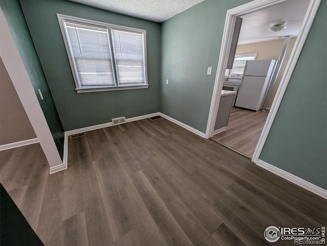 525 Jackson St, Sterling, CO 80751 - unfurnished room with dark wood-type flooring, baseboards, and a textured ceiling