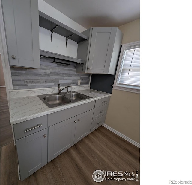 525 Jackson St, Sterling, CO 80751 - kitchen with open shelves, a sink, decorative backsplash, baseboards, and dark wood-style flooring