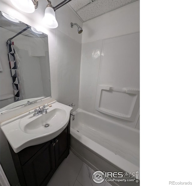 525 Jackson St, Sterling, CO 80751 - full bath featuring shower / bath combination with curtain, a drop ceiling, vanity, toilet, and marble look tiles